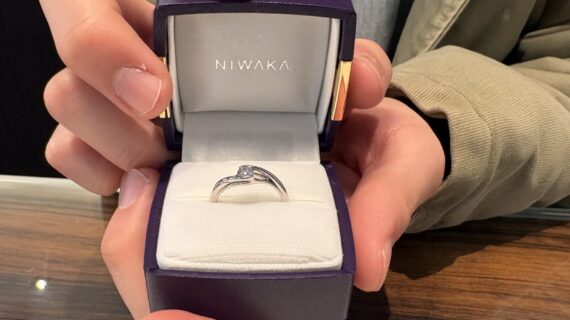 NIWAKAの婚約指輪が入ったケースを開ける男性の手元の画像。