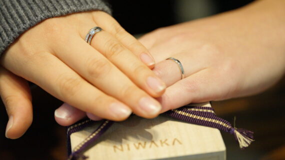 ニワカの婚約指輪と結婚指輪をつけているカップルの写真