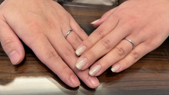 ラザールダイヤモンドの結婚指輪を身に付けるカップルの手元