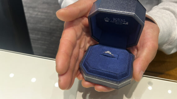 ロイヤル・アッシャーの婚約指輪が入ったケースを持つ男性の手元