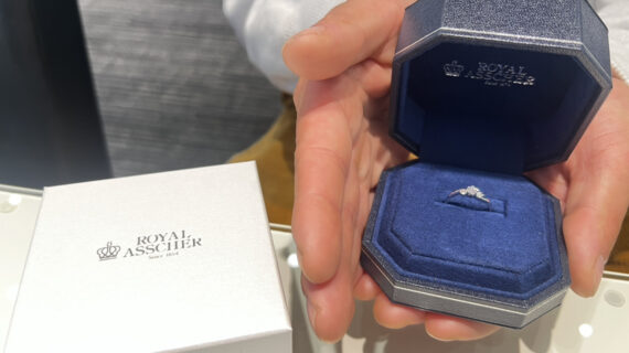 ロイヤル・アッシャーの婚約指輪が入ったケースを持つ男性の手元