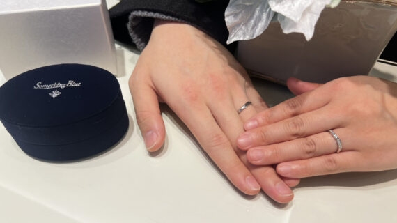 サムシングブルーの結婚指輪を着けたカップルの手元