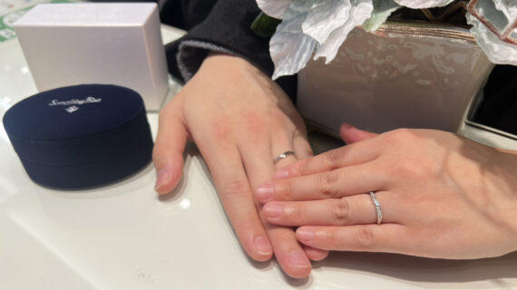 サムシングブルーの結婚指輪を着けたカップルの手元