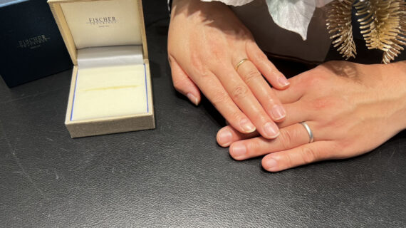 フィッシャーの結婚指輪を着けたカップルの手元