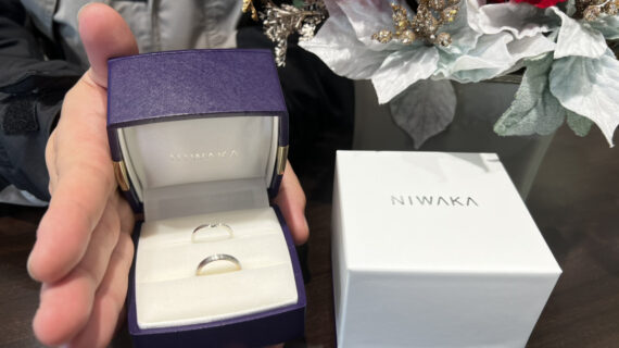 NIWAKA（ニワカ）の結婚指輪が入ったケースを持つ男性の手元
