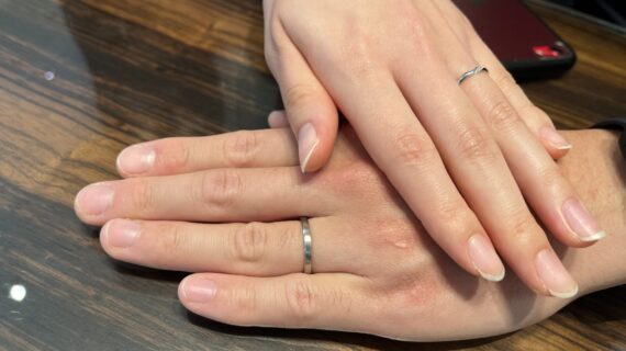 ニワカの結婚指輪を身に付けるカップルの手元