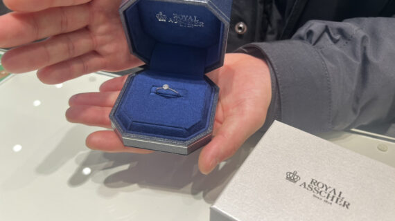 ロイヤル・アッシャーの婚約指輪が入ったケースを持つ男性の手元