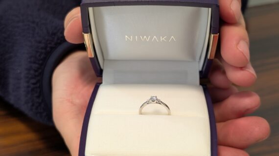 NIWAKA（ニワカ）の婚約指輪が入ったケースを持つ男性の手元
