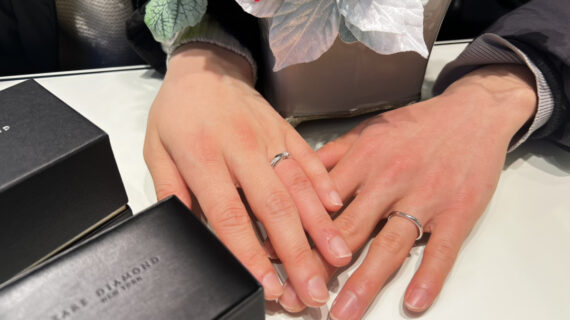 ラザールダイヤモンドの結婚指輪を着けたカップルの手元