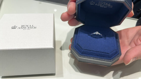 ロイヤル・アッシャーの婚約指輪が入ったケースを持つ男性の手元