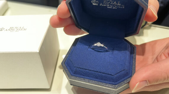 ロイヤル・アッシャーの婚約指輪が入ったケースを持つ男性の手元