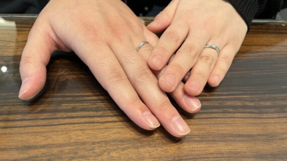 ロイヤルアッシャーの結婚指輪を身に付けるカップルの手元