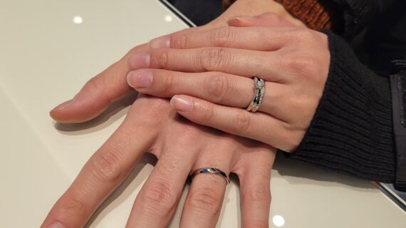ラザールダイヤモンドの婚約指輪と結婚指輪を着けたカップルの手元