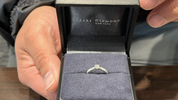 ラザールダイヤモンドの婚約指輪のケースを持つ男性