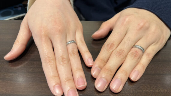 ロイヤル・アッシャーの結婚指輪を着けた男女の手元