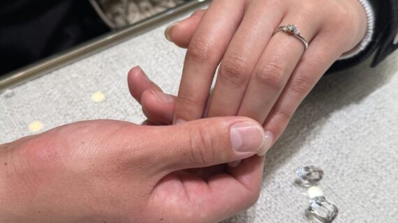 婚約指輪をつけている女性様の手を握る男性の手