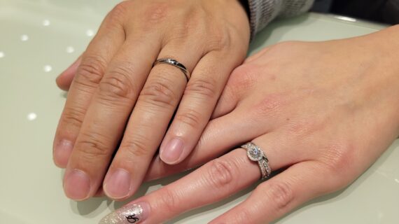 ロイヤル・アッシャーの婚約指輪と結婚指輪を着けたカップルの手元