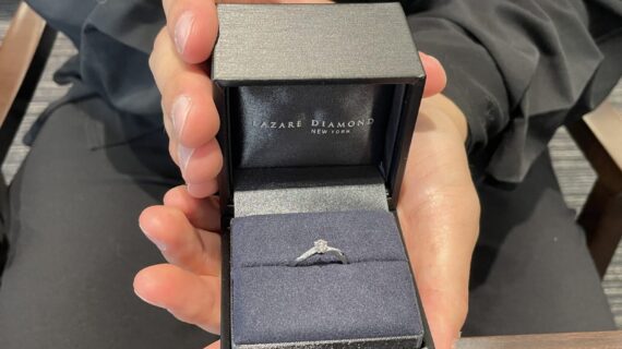 ラザールダイヤモンドの婚約指輪を持っている男性の写真