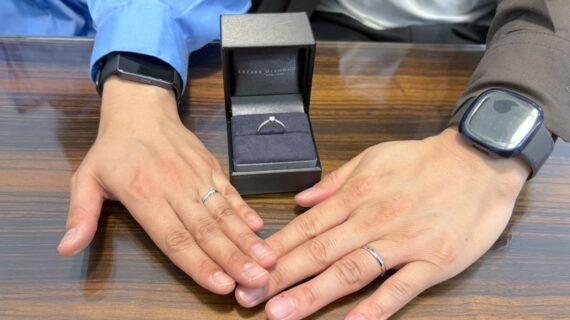 ラザールダイヤモンドの婚約指輪、ロイヤルアッシャーの結婚指輪をつけたカップル