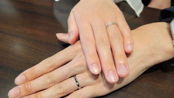 ロイヤル・アッシャーの結婚指輪を着けたカップルの手元