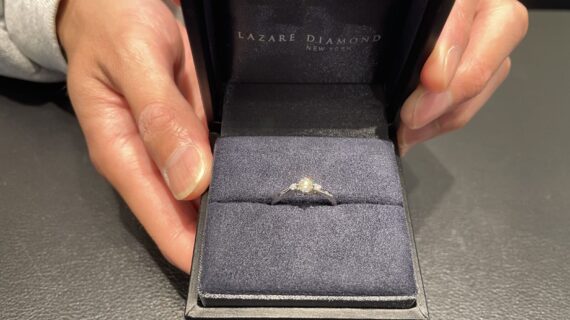 ラザールダイヤモンドの婚約指輪を持っている男性の写真