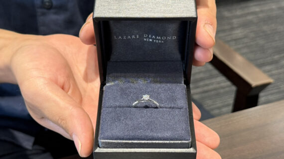 ラザールダイヤモンドの婚約指輪を持った男性の手元