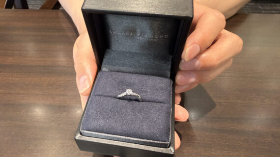 ラザールダイヤモンドの婚約指輪を持った男性の手元