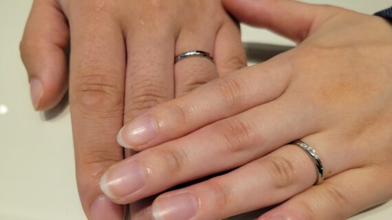 ロイヤル・アッシャーの結婚指輪を着けたカップルの手元