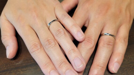 ロイヤル・アッシャーの結婚指輪を着けたカップルの手元