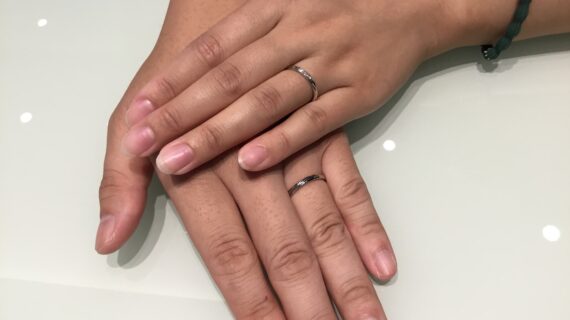 ラザールダイヤモンドの結婚指輪を着けたカップルの手元
