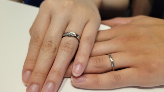 ロイヤル・アッシャーの結婚指輪を着けたカップルの手元