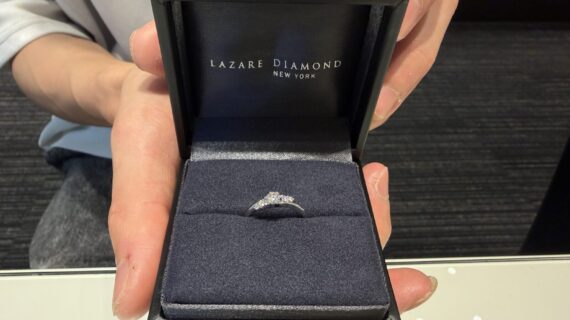 ラザールダイヤモンドの婚約指輪を持っている男性の写真