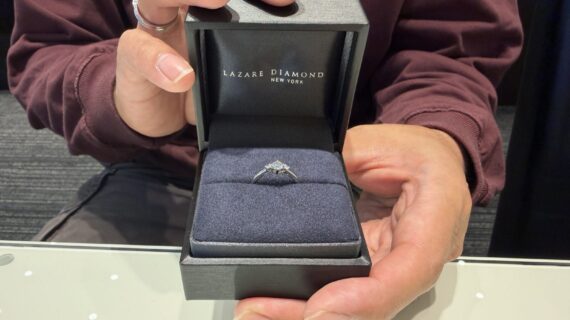 ラザールダイヤモンドの婚約指輪を持っている男性の写真