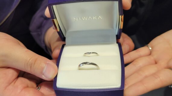NIWAKA（ニワカ）の結婚指輪を持つカップルの手元